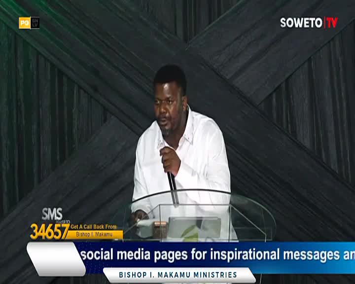 A man in a white shirt speaks into a microphone at a podium. Soweto TV's logo is visible in the background.