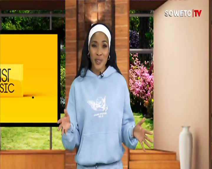 A woman in a light blue hoodie stands with her hands outstretched, speaking into a microphone. Behind her, a bright yellow graphic displays "SIST MUSIC" while Soweto TV's logo appears in the corner. A woman in a light blue hoodie stands with her hands outstretched, speaking into a microphone. Behind her, a bright yellow graphic displays "SIST MUSIC" while Soweto TV's logo appears in the corner.