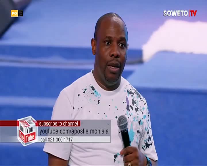 A man in a white t-shirt with a splatter pattern speaks into a microphone. A graphic overlay from Soweto TV displays contact information for a YouTube channel. A man in a white t-shirt with a splatter pattern speaks into a microphone. A graphic overlay from Soweto TV displays contact information for a YouTube channel.