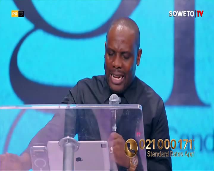 The man in the black shirt leans into the microphone, his face animated as he speaks. A phone number flashes on the screen, a common sight during Soweto TV broadcasts. The man in the black shirt leans into the microphone, his face animated as he speaks. A phone number flashes on the screen, a common sight during Soweto TV broadcasts.