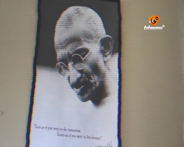 A black and white portrait of Gandhi fills the screen, with a quote beneath his image. The Tshwane TV logo is visible in the top right corner.
