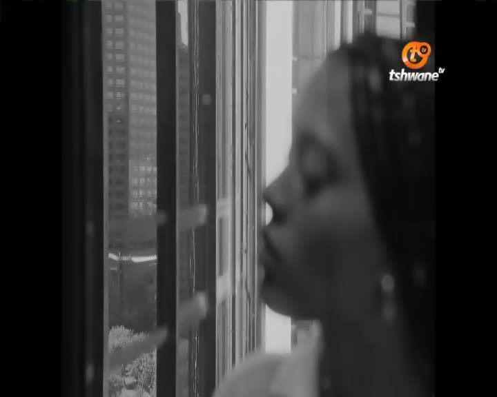 A young woman looks out a window, her profile sharp against the blurred buildings of Tshwane. The city hums with a quiet energy, a familiar backdrop to her contemplation.