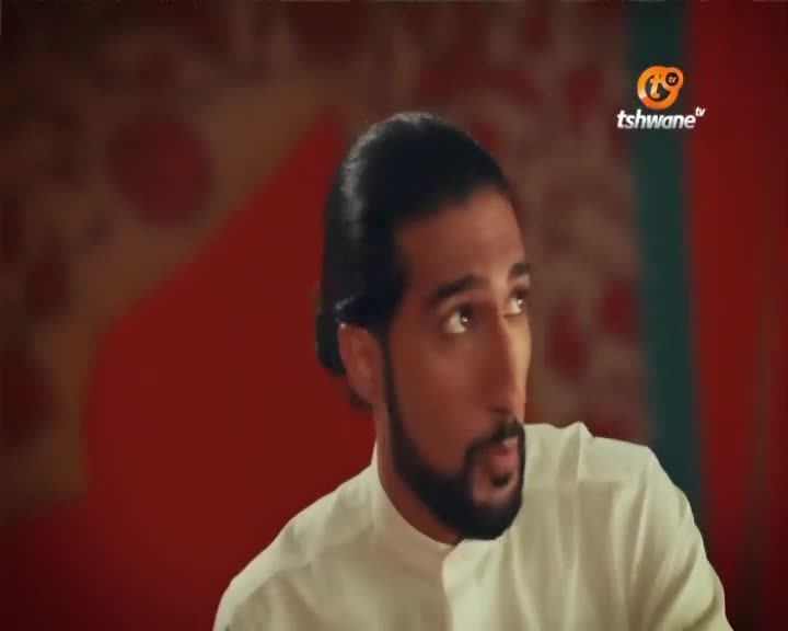 A man with dark hair pulled back and a beard looks intently to his right. The Tshwane TV logo is visible in the upper right corner.