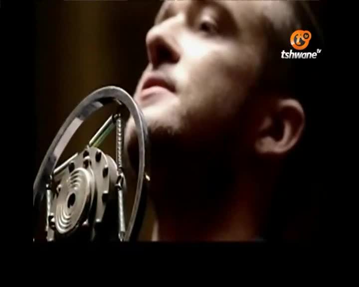 A man's face is close to a vintage microphone, his eyes closed as if lost in song. The Tshwane TV logo appears in the corner, a reminder of where this performance is being broadcast.