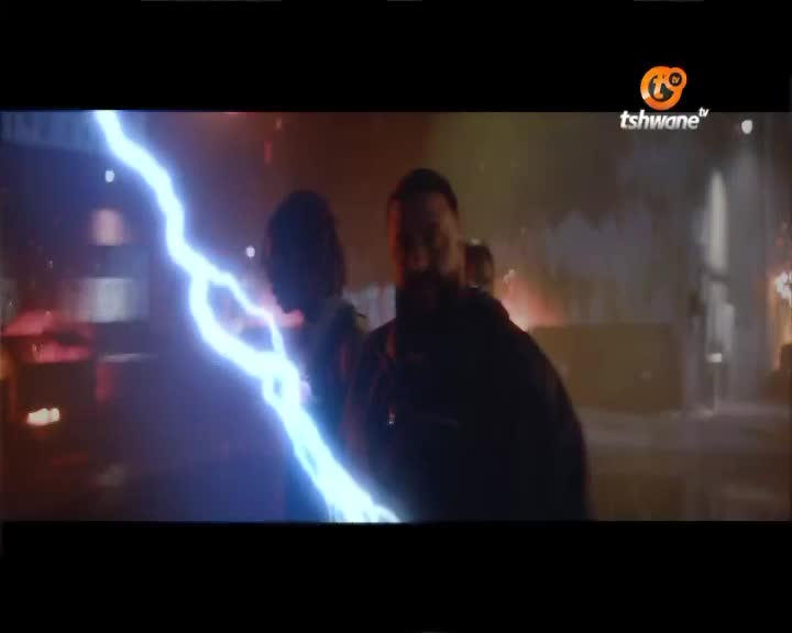 A bright blue energy bolt cracks through the air, illuminating the faces of two people caught in its path. The Tshwane TV logo is visible in the corner, suggesting this scene is from a broadcast.