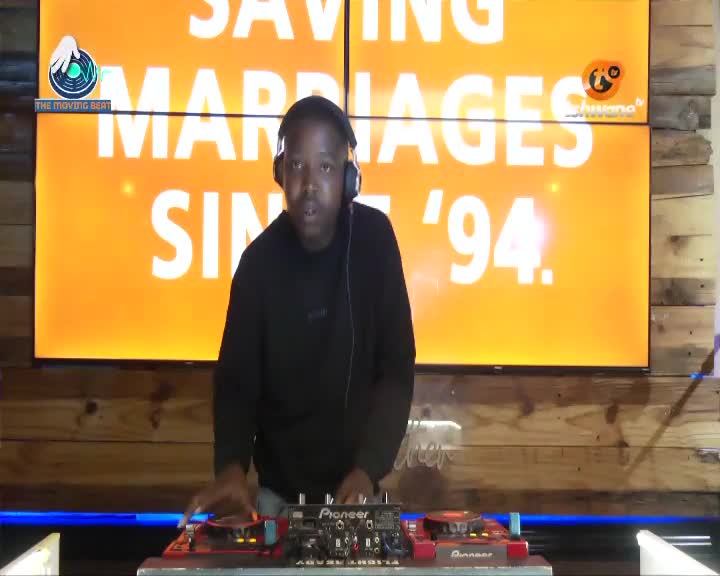 My hands are on the DJ decks, mixing tracks for Tshwane TV. The large screen behind me displays "SAVING MARRIAGES SINCE '94."