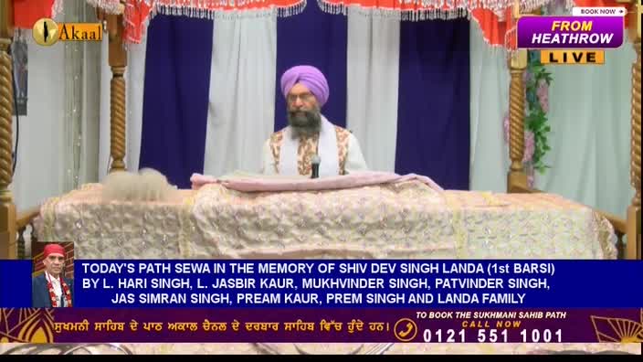 A man with a long beard and a turban sits behind a table, speaking into a microphone. The Akaal Channel logo is visible, and the broadcast is live from Heathrow in the United Kingdom.
