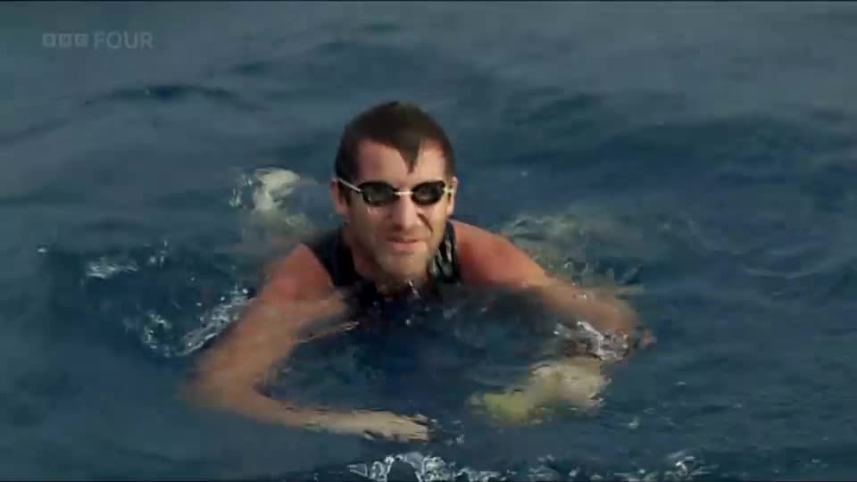 A man in goggles swims towards me, his arms pulling through the choppy water. The BBC Four logo is visible in the corner, indicating this is a broadcast from the UK.
