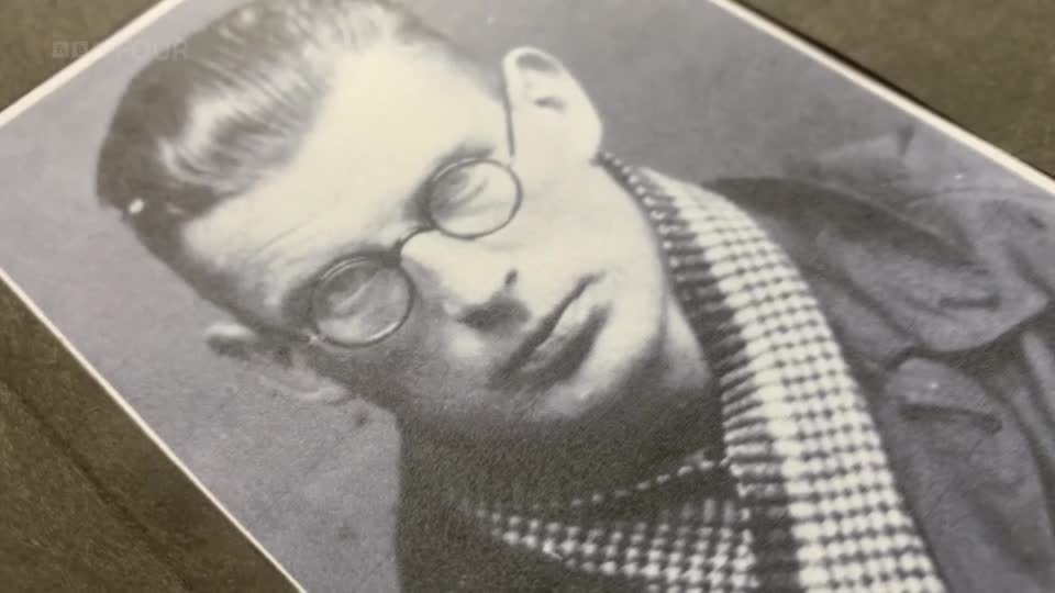A black and white photograph of a young man wearing round spectacles and a checkered scarf. The BBC Four logo is visible in the corner.
