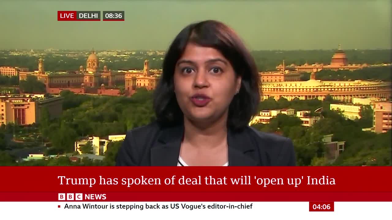 A woman in a black blazer is speaking directly to the camera, with a cityscape visible behind her. The BBC News graphic at the bottom discusses a deal regarding India.
