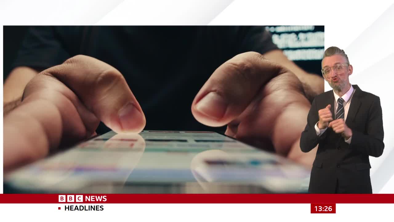 Fingers tap and swipe across a phone screen, the light reflecting off the glass. A BBC News presenter is in the frame, signing.
