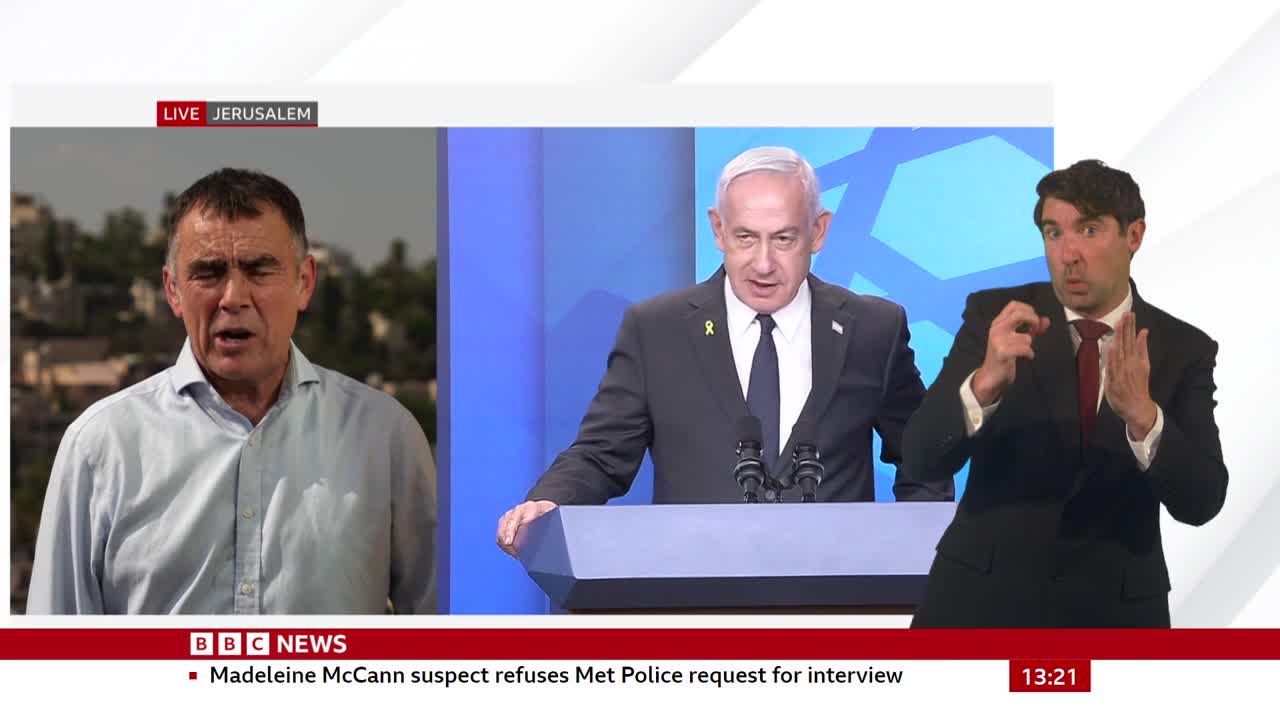 On the BBC News broadcast from Jerusalem, a man in a suit is signing, while two other men are visible on screen. One of them is speaking, and the other is standing behind a podium.
