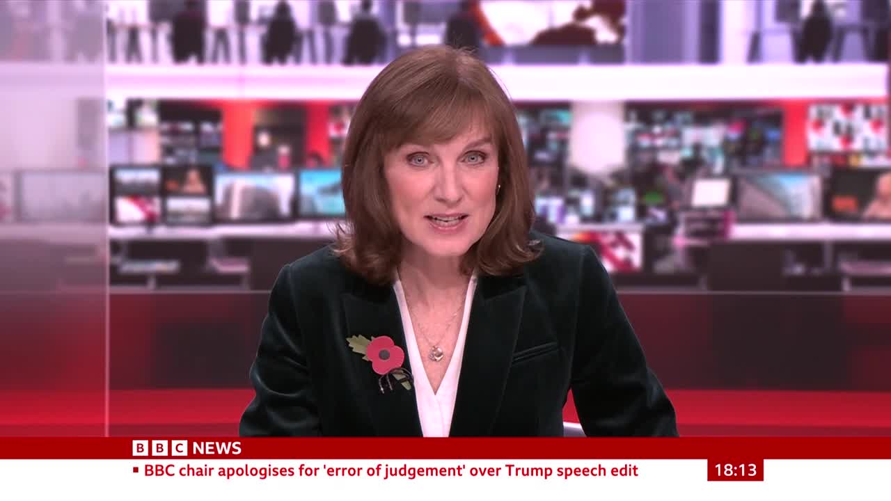 A woman in a dark green blazer is speaking directly to the camera, a poppy pinned to her lapel. Behind her, screens and a red graphic identify the BBC News broadcast from the United Kingdom.
A woman in a dark green blazer is speaking directly to the camera, a poppy pinned to her lapel. Behind her, screens and a red graphic identify the BBC News broadcast from the United Kingdom.