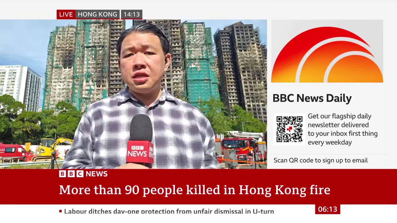 A BBC News reporter in Hong Kong speaks into a microphone, with a backdrop of charred high-rise buildings and emergency vehicles. The screen displays a headline about a fire that killed over 90 people.
