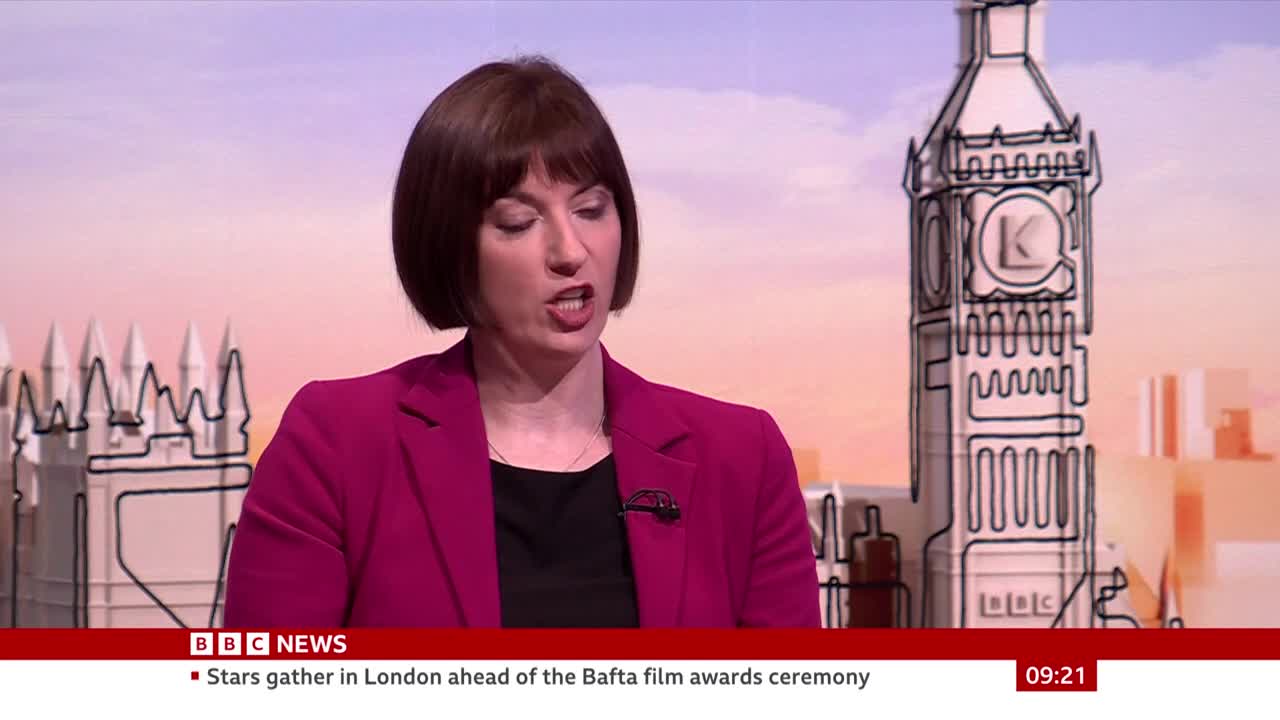 A woman in a bright pink jacket speaks directly to the camera, her voice clear and steady. Behind her, a stylized outline of Big Ben stands against a soft, pastel sky. A woman in a bright pink jacket speaks directly to the camera, her voice clear and steady. Behind her, a stylized outline of Big Ben stands against a soft, pastel sky.