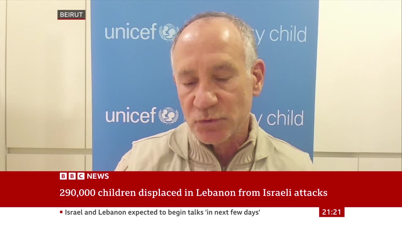 A man speaks in front of a UNICEF backdrop, his words relayed by BBC News. The ticker below reports on the displacement of children in Lebanon.