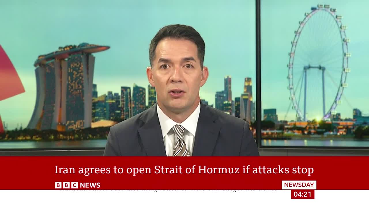 A man in a suit speaks directly to the camera, with a city skyline and a large Ferris wheel behind him. A red banner at the bottom of the screen reads "Iran agrees to open Strait of Hormuz if attacks stop" and "BBC NEWS".