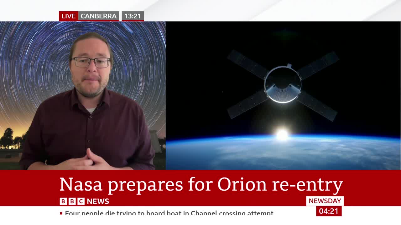 A spacecraft with four solar panels hangs in the blackness of space. Below it, the curve of the Earth glows with sunrise.