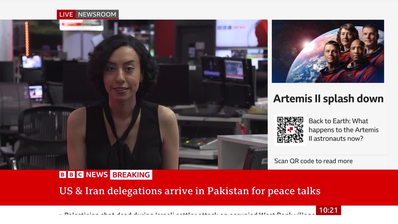 A BBC News presenter stands in a newsroom, with a breaking news banner about US and Iran delegations arriving in Pakistan. To her right, a graphic displays the Artemis II astronauts with a headline about their splashdown.