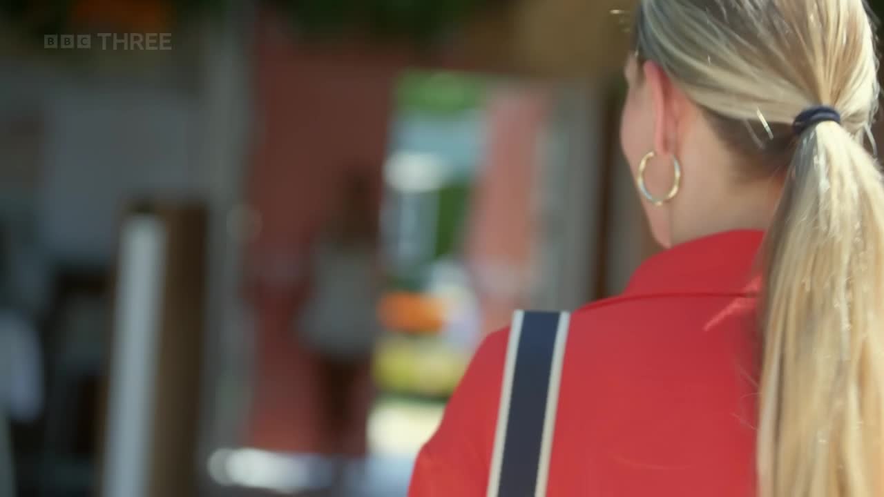 A woman in a red jacket walks away, her blonde ponytail bouncing gently. The BBC Three logo is visible in the top left corner.
