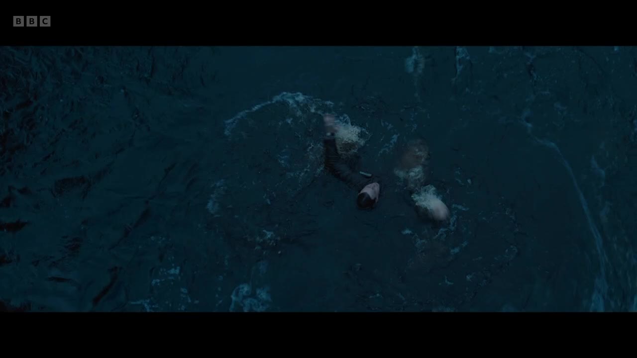 A person in dark clothing struggles in the choppy water, their arm raised. White splashes erupt around them, as if something else is nearby.
A person in dark clothing struggles in the choppy water, their arm raised. White splashes erupt around them, as if something else is nearby.