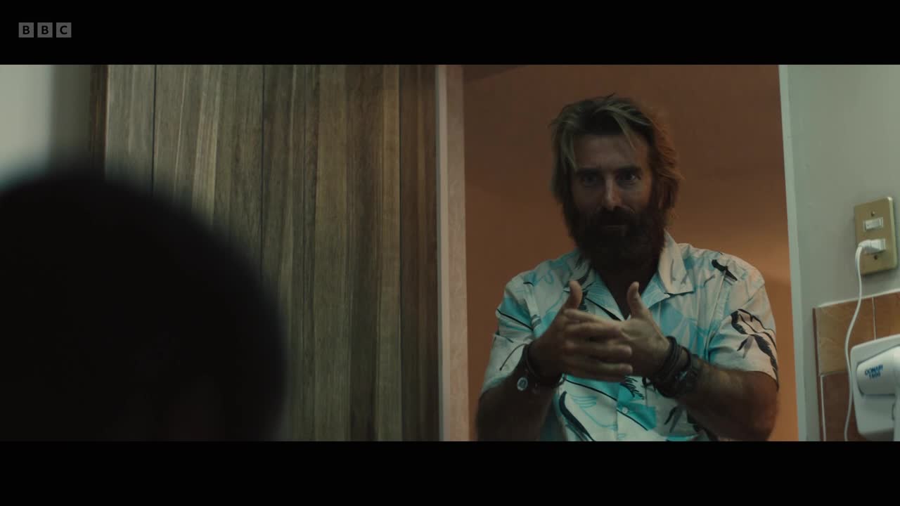 The man in the patterned shirt, with a thick beard, is smiling and giving a thumbs-up. He's standing in what looks like a bathroom, the walls a mix of wood and tile.
The man in the patterned shirt, with a thick beard, is smiling and giving a thumbs-up. He's standing in what looks like a bathroom, the walls a mix of wood and tile.
