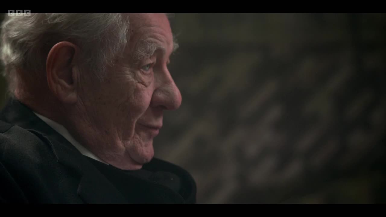 The BBC Two logo appears in the top left corner. An elderly man with white hair, wearing a dark suit, turns his head to the right, a faint smile on his lips.