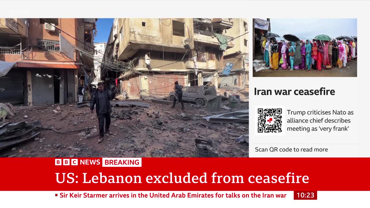 A man walks through debris-strewn streets past damaged buildings. Another figure stands guard near a damaged vehicle.