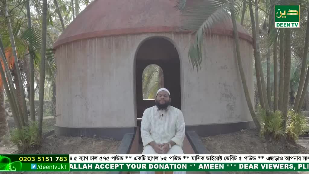 A man in a white robe sits in front of a domed structure, speaking into a microphone. The Deen TV logo and a phone number from the United Kingdom are visible in the lower corner.
