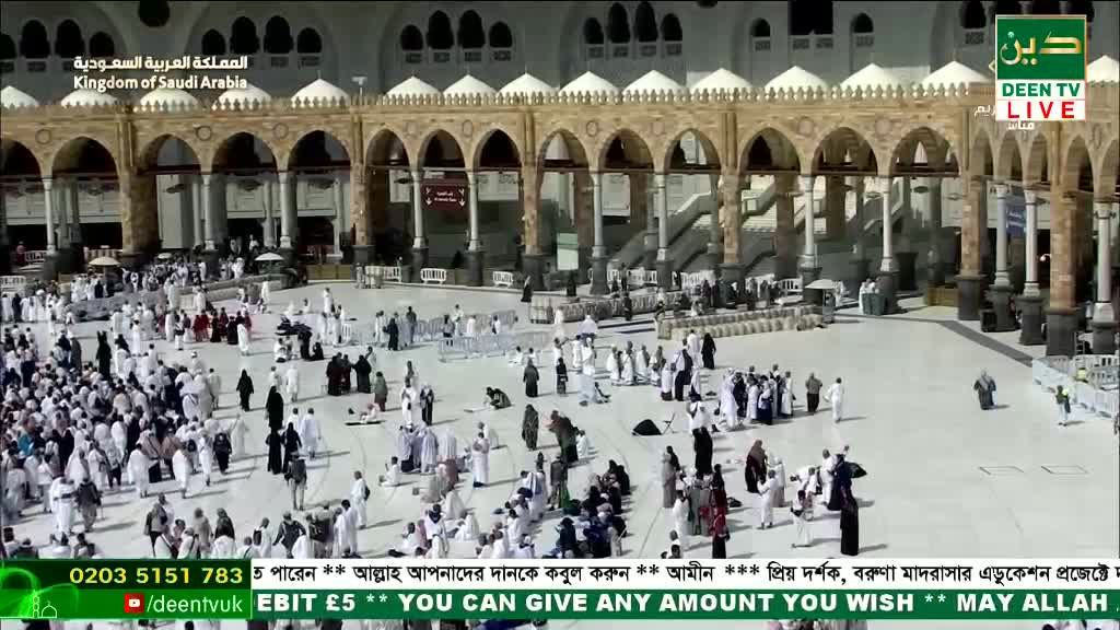 People in white garments move slowly across the vast courtyard, some kneeling in prayer. The scene is broadcast live on Deen TV from the Kingdom of Saudi Arabia.
