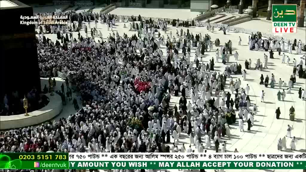 Thousands of people, mostly dressed in white, are circling a large black structure. The live broadcast from Deen TV in the UK shows the continuous movement of the crowd.
