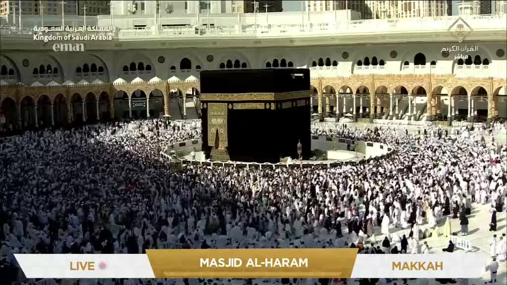 Thousands of people in white garments are circling the black Kaaba, a central structure. The scene is being broadcast live on the Eman Channel from Masjid al-Haram in Mecca.
