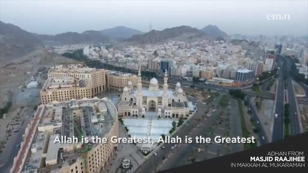 From this vantage point, a large mosque dominates the city, its white facade gleaming against the buildings. The sound of the adhan, broadcast by Eman Channel, echoes across the urban landscape.
