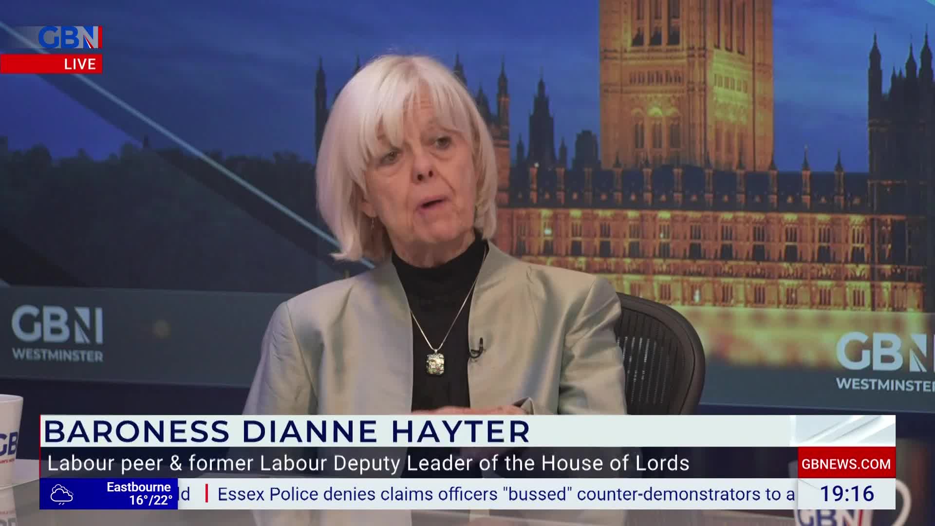 Baroness Dianne Hayter is speaking on GB News, the Houses of Parliament visible behind her. She's wearing a light jacket and a necklace, and the lower third of the screen displays her name and title.
