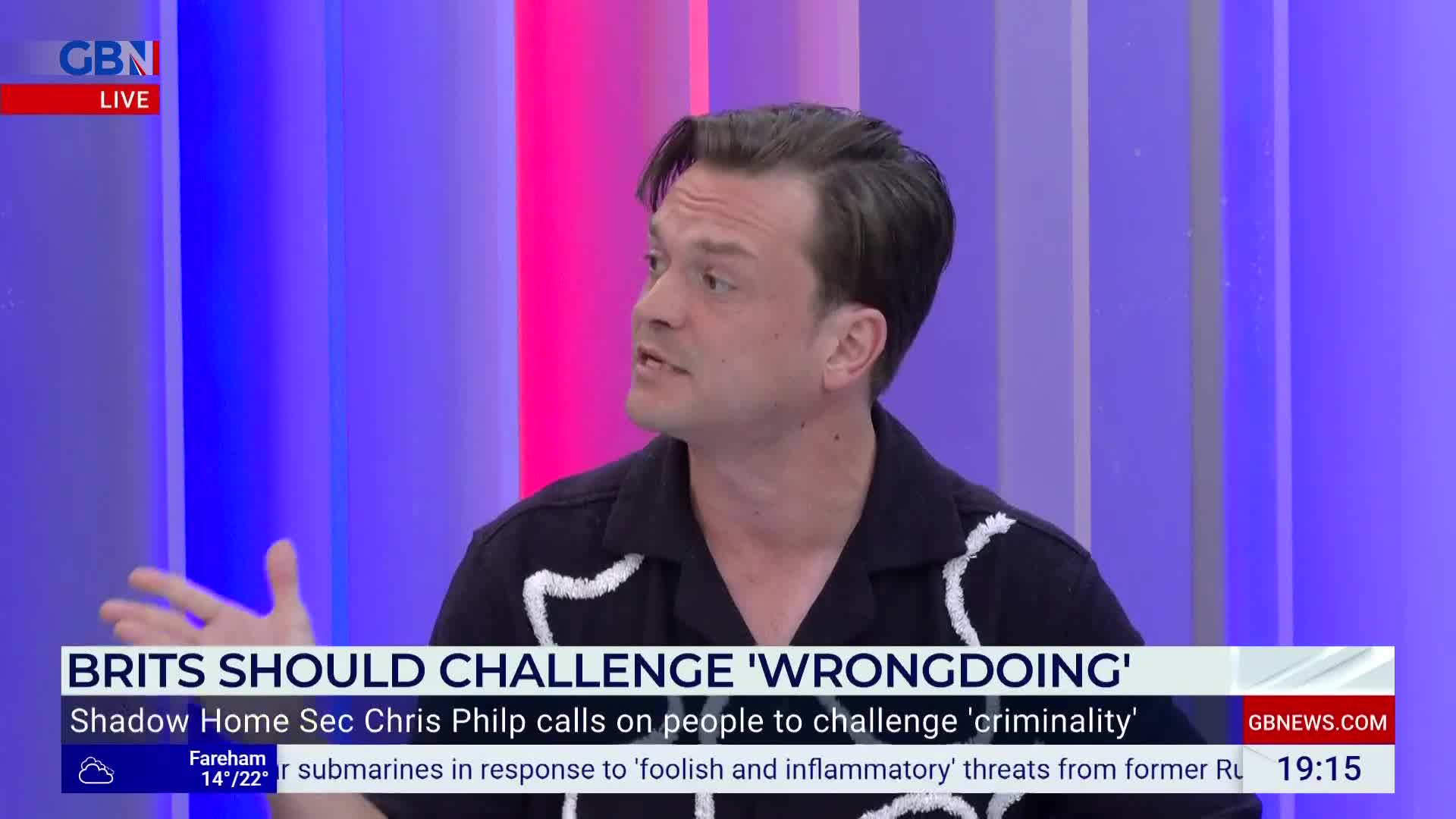 On GB News, a man in a dark shirt with white trim gestures emphatically while speaking. A chyron declares that Brits should challenge wrongdoing.
