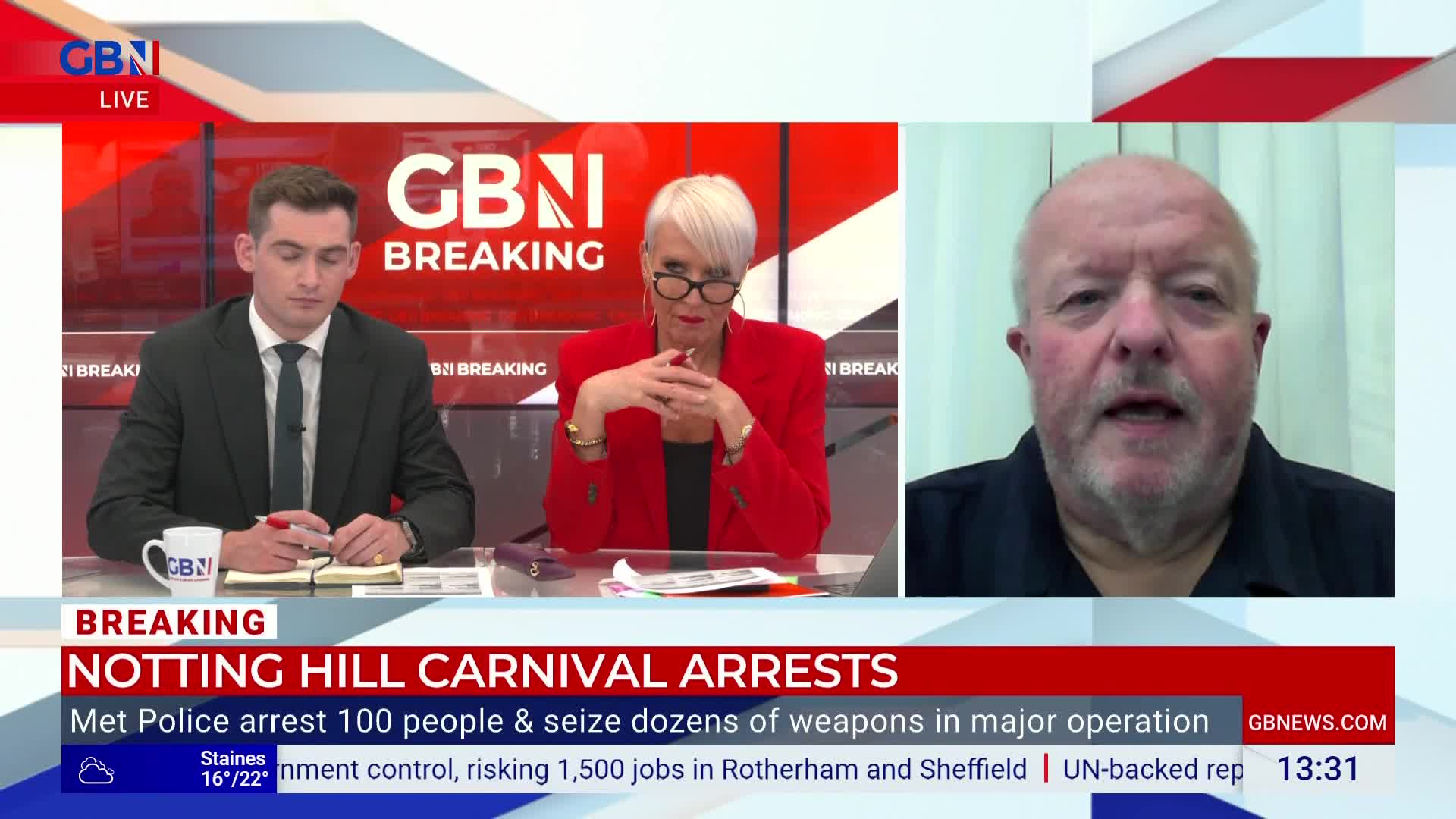 A man in a black shirt is speaking on GB News, his face filling the right side of the screen. The news anchors in the studio sit at a desk, listening to the interview about the Notting Hill Carnival arrests.
