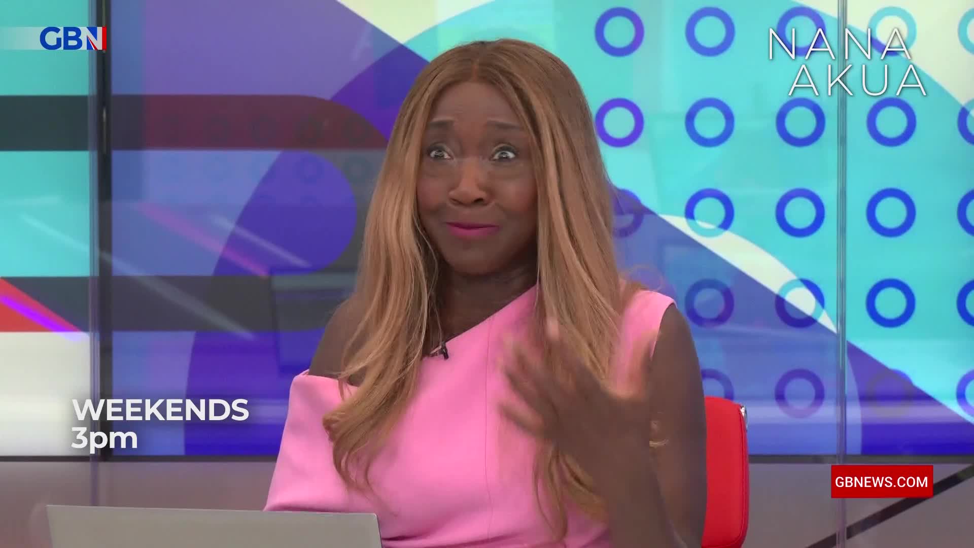 The GB News presenter, Nana Akua, gestures with her right hand while speaking. Her expression is animated, with wide eyes and a slight smile.
