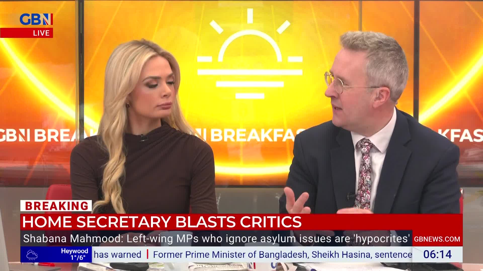 On GB News, a man in a suit gestures with his right hand as he speaks. The woman next to him, with long blonde hair, looks on with a neutral expression.
