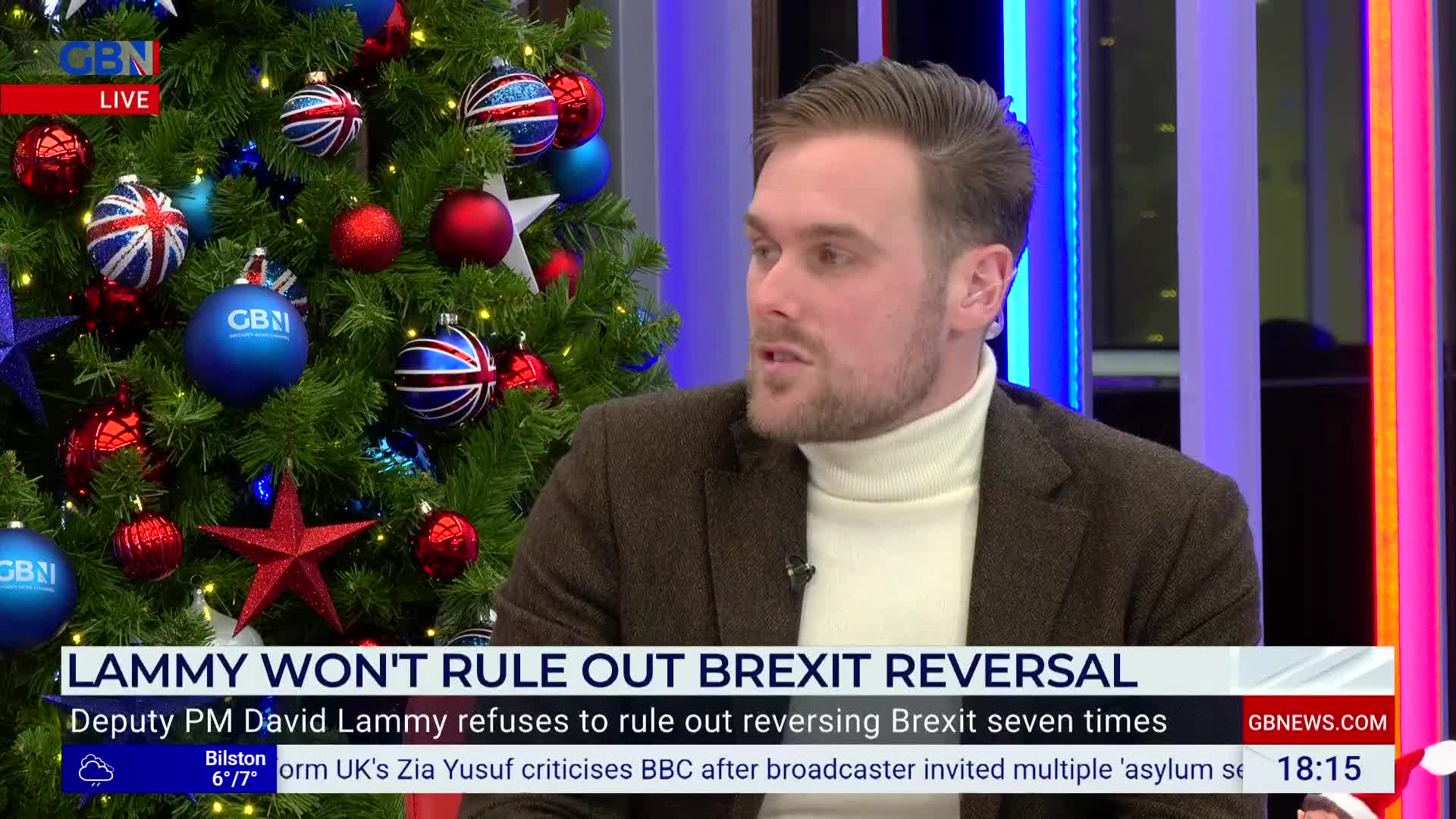 A man in a brown jacket and a white turtleneck is speaking on GB News, framed by a Christmas tree decorated with Union Jack ornaments. The lower third of the screen highlights the day's political discussion about Brexit.
A man in a brown jacket and a white turtleneck is speaking on GB News, framed by a Christmas tree decorated with Union Jack ornaments. The lower third of the screen highlights the day's political discussion about Brexit.