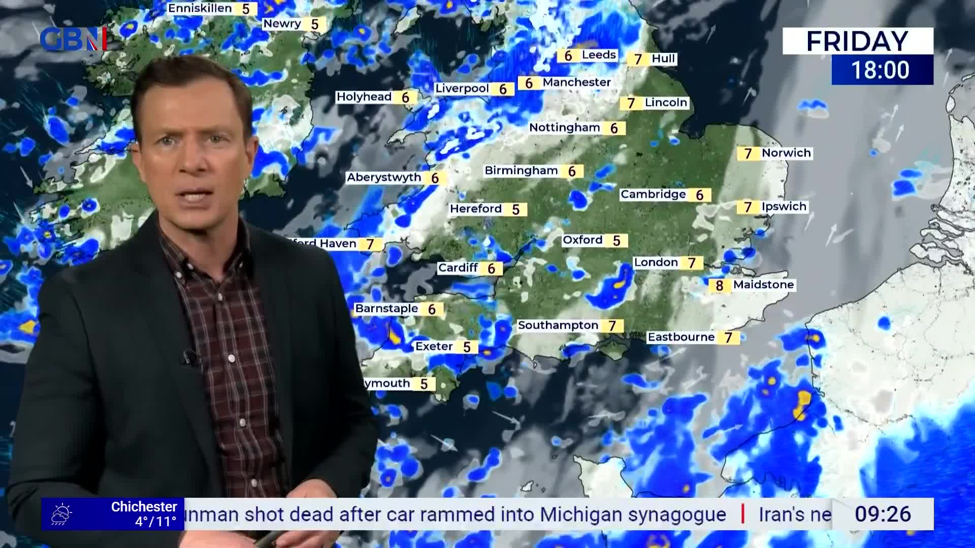 Rain showers are moving across England, with temperatures around 5 to 7 degrees Celsius. A man in a dark jacket stands before a weather map displaying these conditions.