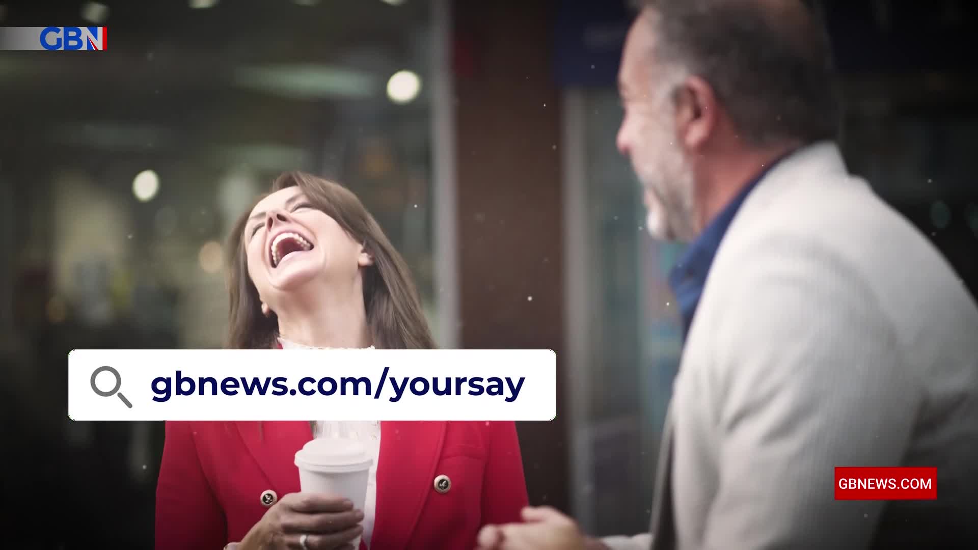 A woman in a bright red jacket throws her head back in laughter, clutching a coffee cup. Beside her, a man in a light suit turns his head, also smiling.