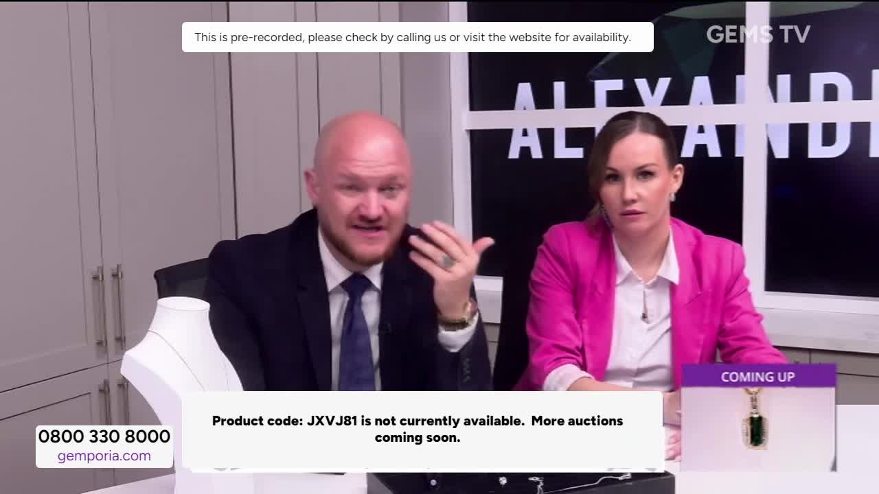 A man in a suit gestures animatedly while speaking, and a woman in a pink blazer sits beside him, looking directly at the camera. The Gems TV logo is visible, and a chyron states that the product code is unavailable.
