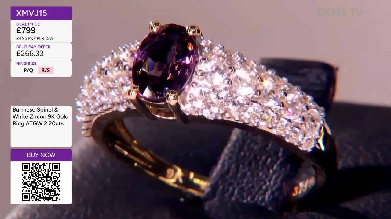 A gold ring, set with a large oval purple stone and a band encrusted with smaller white gems, is being shown on a dark surface. The price and details flash on screen, as this piece is presented on Gems TV.
