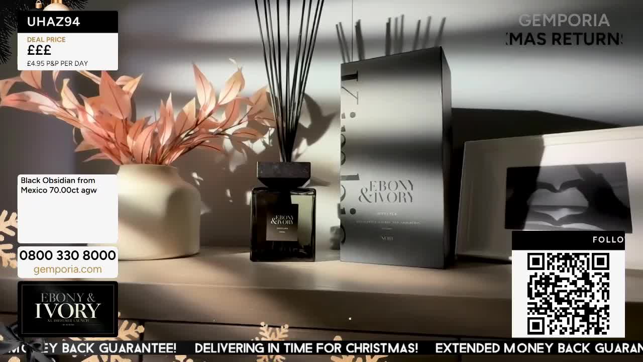A perfume bottle and its box sit on a shelf, lit by a soft light. The Gems TV logo is visible in the corner, and a QR code is displayed nearby.
