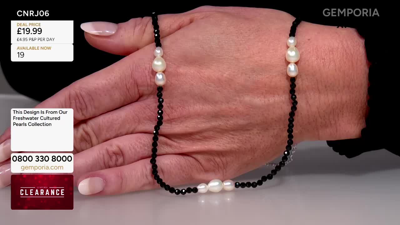 A hand, with polished nails, holds a necklace of white pearls and black beads. The necklace is displayed on Gems TV, with a price tag and phone number visible in the corner.
A hand, with polished nails, holds a necklace of white pearls and black beads. The necklace is displayed on Gems TV, with a price tag and phone number visible in the corner.