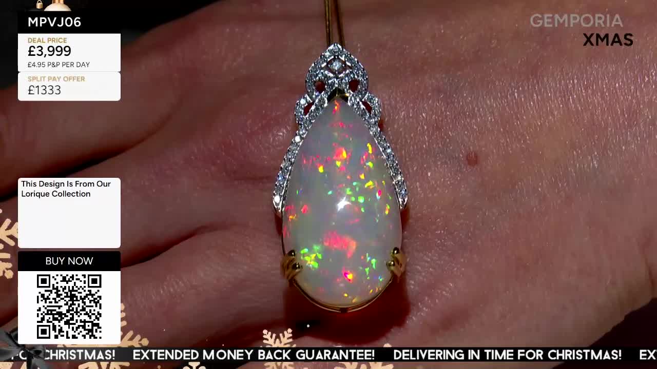 A pear-shaped opal pendant, set with diamonds, is held up against a hand on a Gems TV show. The stone shimmers with flashes of red, green, and yellow light.
A pear-shaped opal pendant, set with diamonds, is held up against a hand on a Gems TV show. The stone shimmers with flashes of red, green, and yellow light.