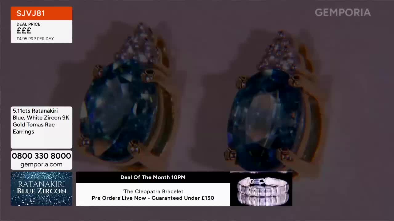 A pair of large, oval blue gemstones set in gold earrings sparkle under the lights. A silver bracelet is displayed below, with text indicating a deal on "The Cleopatra Bracelet."