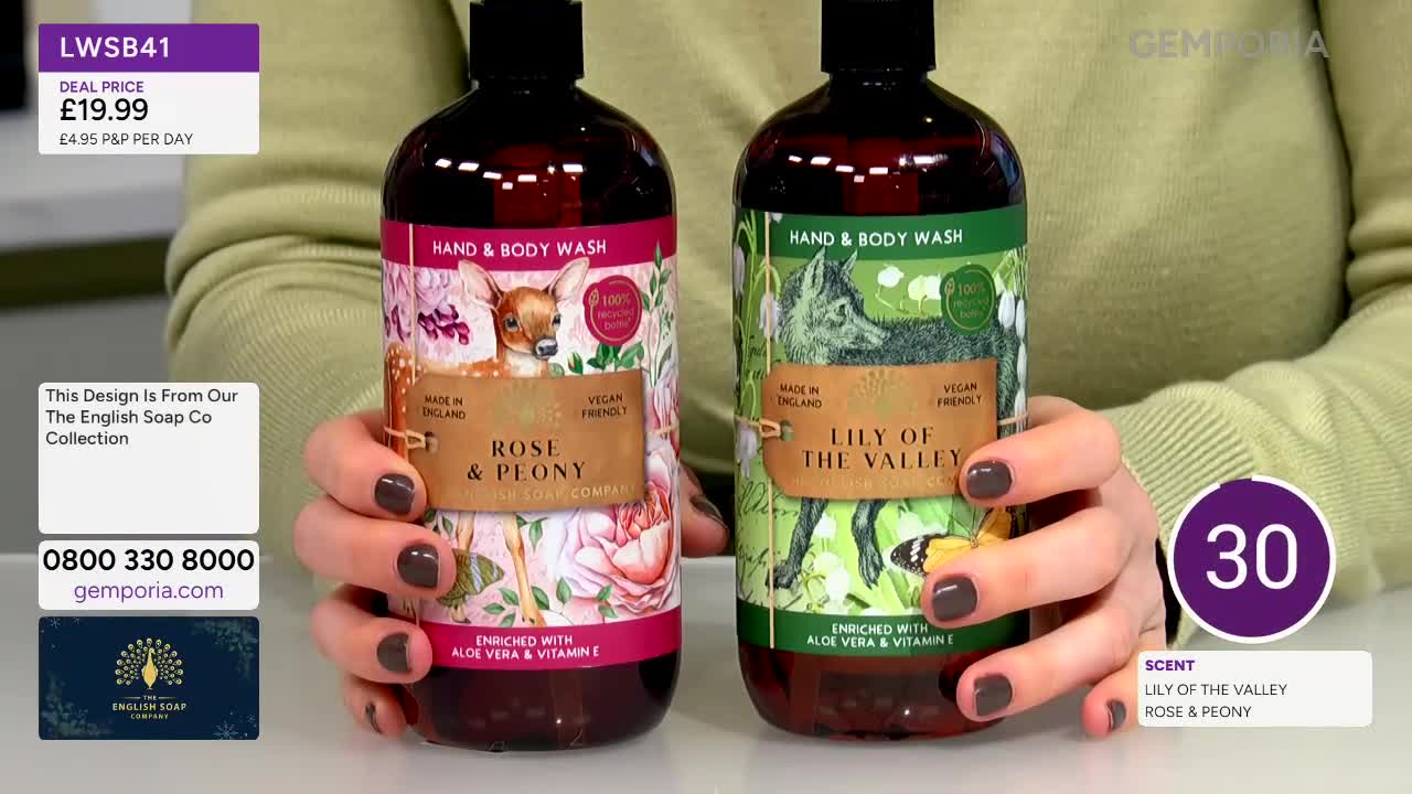 Two bottles of hand and body wash, one with a deer and rose design, the other with a fox and lily of the valley, are held up. The presenter's hands, with dark nail polish, gently cradle the bottles as they are displayed.