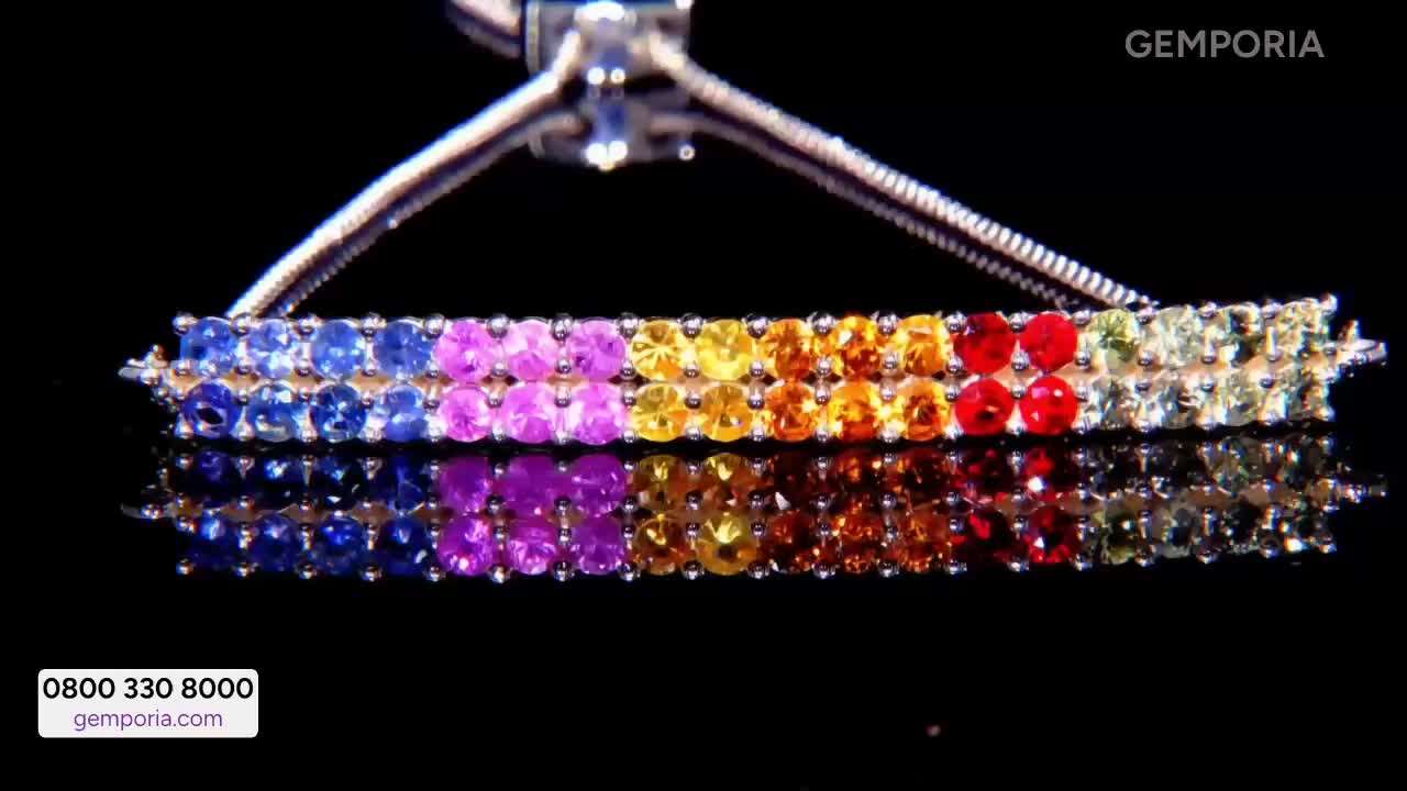 A delicate silver chain suspends a double row of colourful gemstones, each stone catching the light. The bracelet, displayed on Gems TV, transitions from deep blues and purples to vibrant yellows, oranges, and reds.