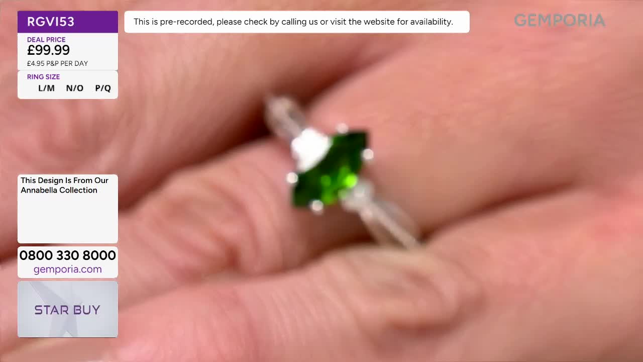 A hand turns a silver ring, its emerald stone catching the light. The Gemporia logo is visible in the background.